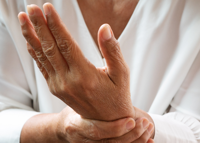 Mujer con uno de los primeros síntomas de artritis reumatoide: dolor en las articulaciones de las manos. Mujer con uno de los primeros síntomas de artritis reumatoide: dolor en las articulaciones de las manos.